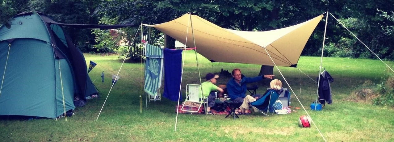 Tent en tentzeil kamperen aan de bosrand met teken