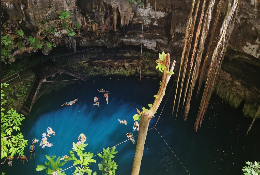 Cenote Mexico met lianen en zwemmers